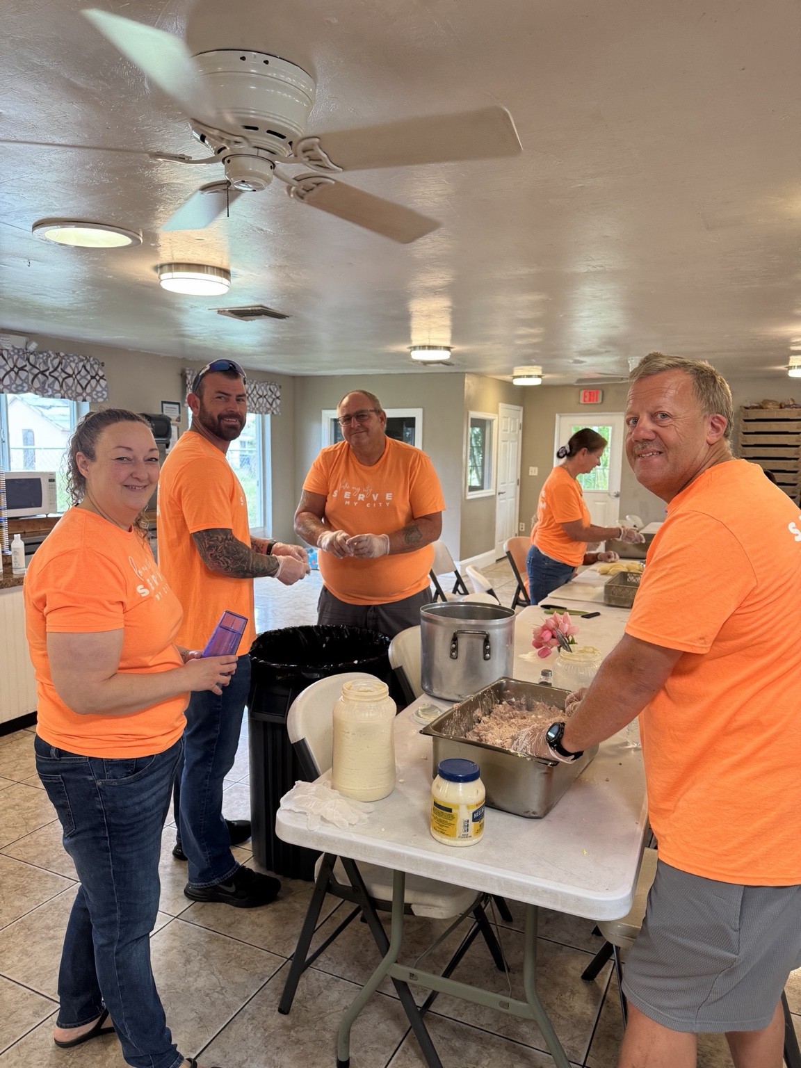 Volunteers working together at a food preparation table
